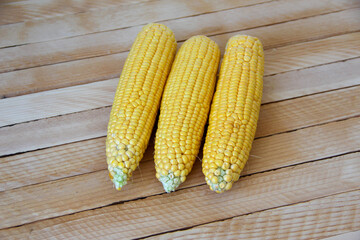 Cobs of fresh young corn on wooden background