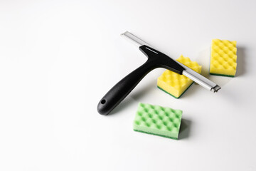 cleaning tools, scraper, window nozzle and colored washcloths on a white background
