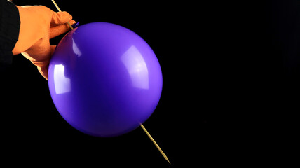 one hand shows the action of stabbing a balloon using a skewer without exploding. The concept of...