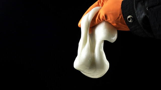 one hand holding slime made from styrofoam dissolved in acetone