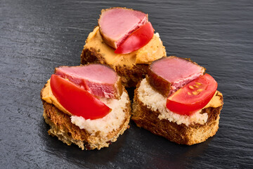 Spanish food tapas. Toast with fresh goat cheese and smoked serrano meat. High resolution image.