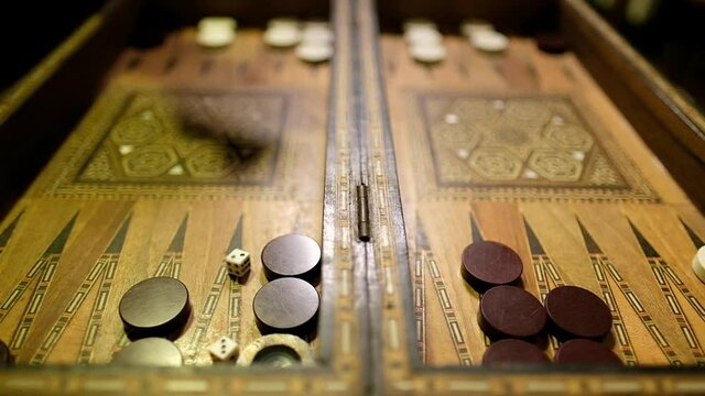 A slow motion clip of a Backgammon game, the cubes are thrown with a very shallow depth of field.