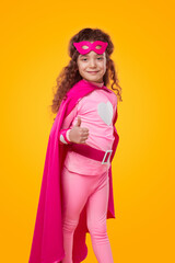 Cheerful superhero girl showing thumb up