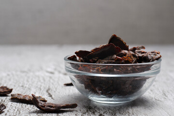 Jerky meat on a concrete background. Dried beef. Glassware. Copy space. Close-up. 