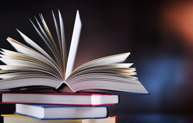Hardcover book lying on a stack of other books