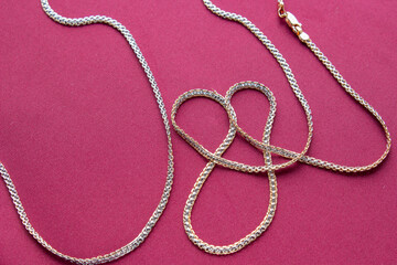 Gold chain on a red background close-up. Jewelry is great for a gift