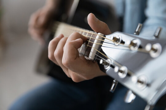 Close Up Young Man Playing String Instrument, Learning Chords Practicing Music, Enjoying Rehearsal, Improving Creative Skills. Professional Male Musician Demonstrating Excellent Musical Technique.