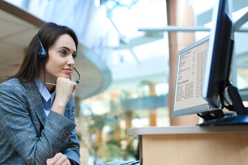 Female customer support operator with headset and smiling.