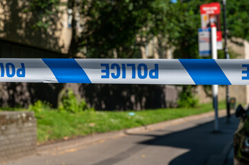 Obraz premium Upside down police cordon tape across a crime scene