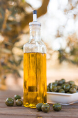 green olives and oil on table in olive grove
