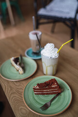 Pasteles, cafes y batido en una mesa de madera