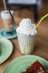 Pasteles, cafes y batido en una mesa de madera