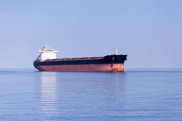 Large cargo ship anchored in the St. Lawrence River seen during a sunny summer afternoon near...