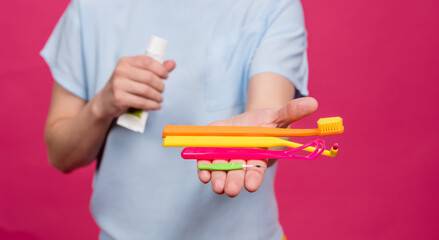 Beautiful young woman uses an oral care kit consisting of a tongue scraper, single tufted and...