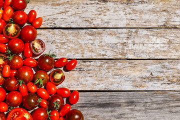 Naklejka na ściany i meble Red ripe tomatoes texture background. Different qualities of tomatoes on the wooden table. Black tomato Solanum lycopersicum.