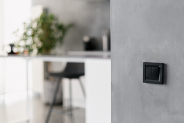 Black light switch on grey wall in kitchen