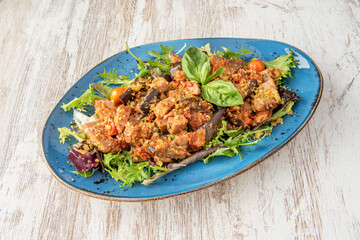 firenze salad with lots of canned tuna, lettuce and basil with cherry tomatoes on a blue plate