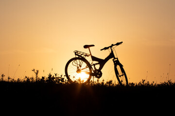 Fototapeta na wymiar Mountains bike silhouette and setting sun, orang sunset.