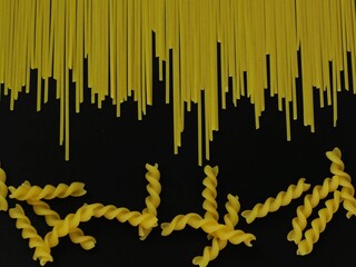 Fusilli and Spaghetti pasta on a black background