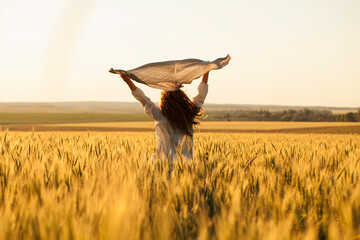 Happy woman with headscarf in the middle of ripe wheat field