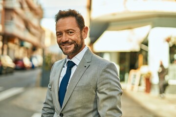 Middle age businessman smiling happy standing at the city.