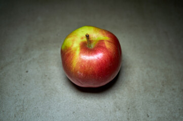 Lightened red apple on grey background