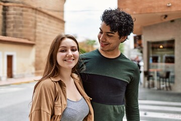 Fototapeta premium Young interracial couple smiling happy and hugging standing at the city.