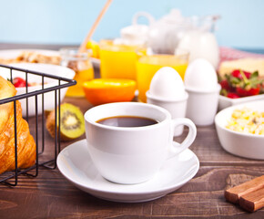 Cup of coffee, juice, eggs, fruits, toasts. Breakfast concept.