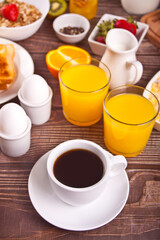 Cup of coffee, juice, eggs, fruits, toasts. Breakfast concept.
