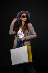 fashionable woman in sunglasses holding shopping bags