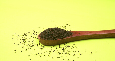 Black Tea Powder or dry dust tea powder, chai patti isolated in wooden bowl with Cardamom, Clove...