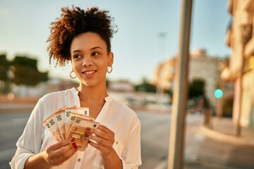 Young african american businesswoman counting 50 euro banknotes at the city.