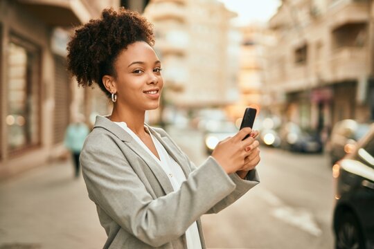 Young african american businesswoman smiling happy using smartphone at the city.