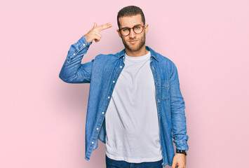 Young caucasian man wearing casual clothes shooting and killing oneself pointing hand and fingers...