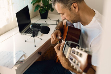 Middle-aged man recording the sound of his guitar while practicing at home.
Conceptual lifestyle
