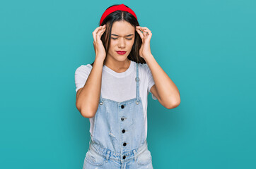 Young hispanic girl wearing casual clothes with hand on head for pain in head because stress. suffering migraine.