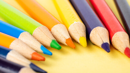 colored pencils close-up on yellow background, drawing training.