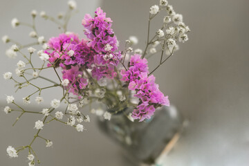 Field flowers in glass vase on gray background