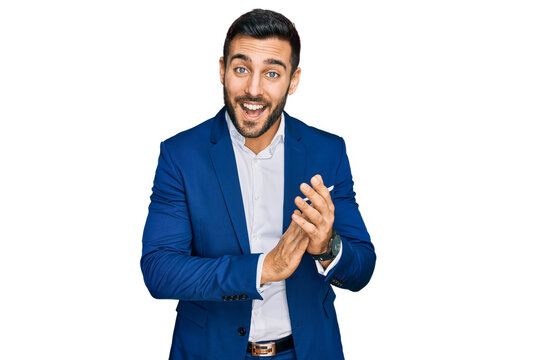 Young hispanic man wearing business jacket clapping and applauding happy and joyful, smiling proud hands together