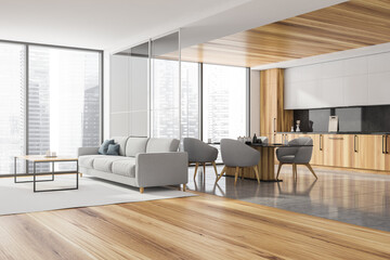 Corner of panoramic kitchen with grey sofa, wooden elements