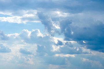 Cloudy sky lit by the sun. Huge clouds in blue sky