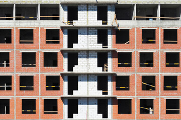Construction background. Architecture of apartment building. Real estate with empty window openings