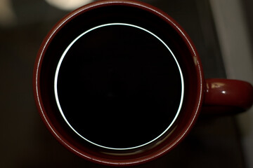 Close up of black coffee with a ring of light on the edges of the mug