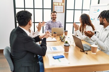 Group of business workers smiling and clapping to partner at the office.