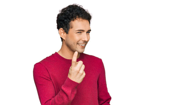 Young handsome man wearing casual clothes beckoning come here gesture with hand inviting welcoming happy and smiling