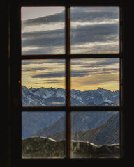 view through the window of an alpine mountain hut against the austrian alps