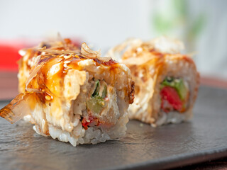 close-up of a sushi roll on a black plate. Traditional Japanese cuisine