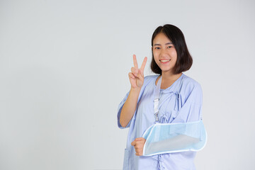 Broken arm girl in right arm sling thumbs up Woman showing pain from health care, broken arm and