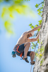 Athletic mid age man in a difficult rock climbing tour in the La Gola climbing area, Sarca Valley,...