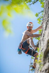 Athletic mid age man in a difficult rock climbing tour in the La Gola climbing area, Sarca Valley, Lake Garda mountains, Trentino Italy